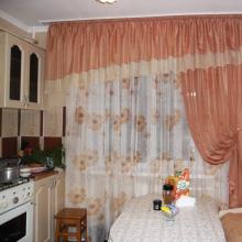 A beautiful curtain for the kitchen is the main element of the interior